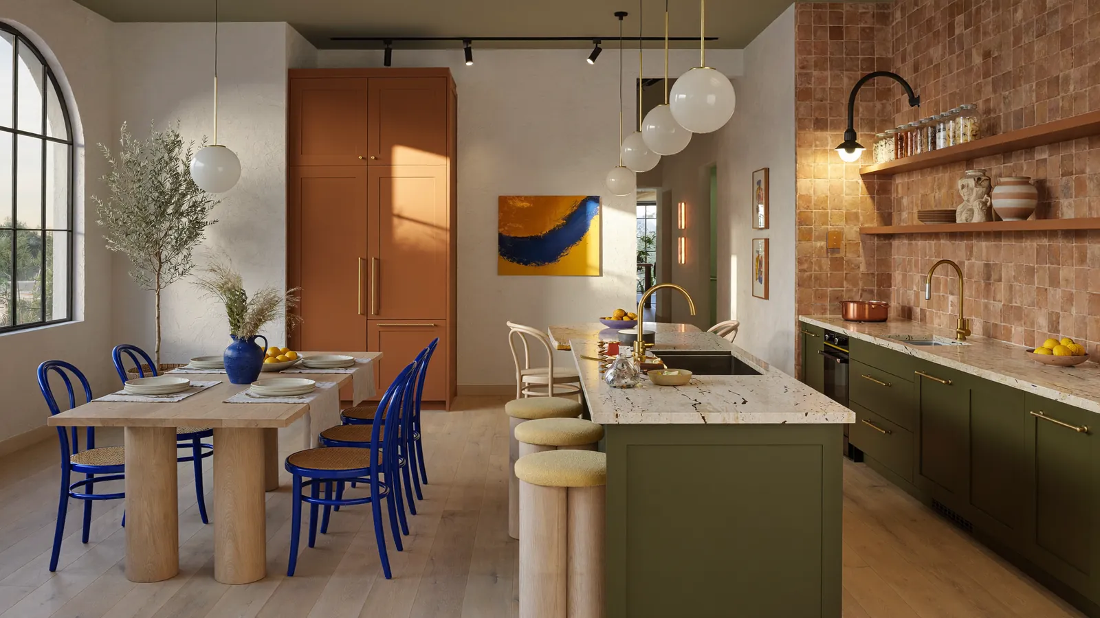 Cucina con isola verde, sedie blu e piastrelle in cotto